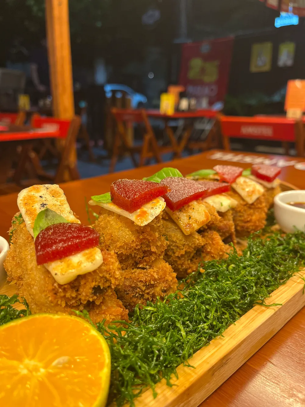 Porção empanada com queijo e goiabada servida na tábua, na varanda do bar